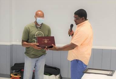 Jefferson County Sheriff Lafayette Woods, Jr., (right) presents custom gun box containing .40 cal  Glock service pistol to Major Randy Dolphin (left) at his retirement celebration.